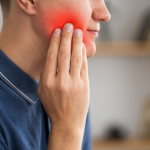 Man grabbing cheek due to tooth pain